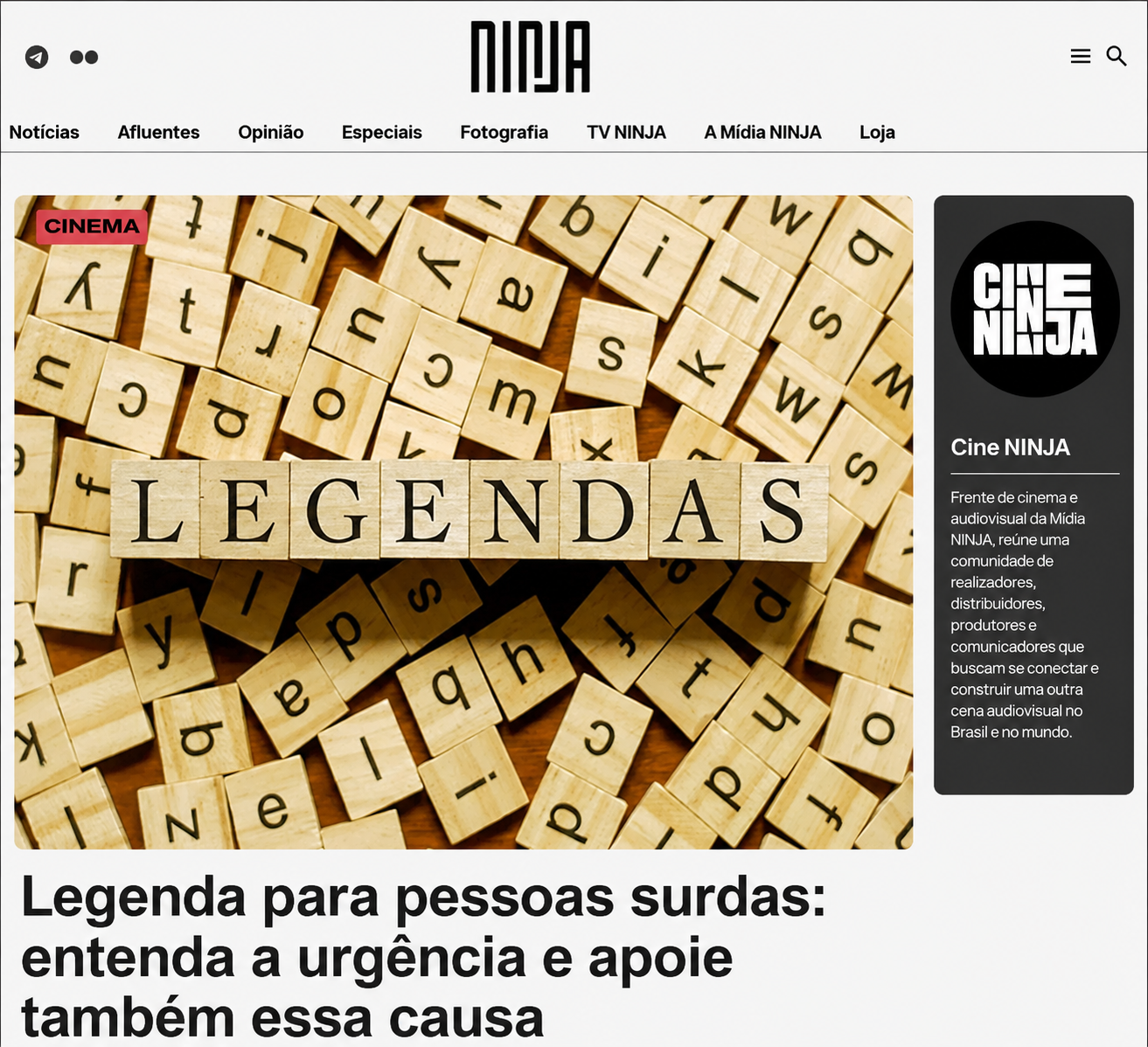 Captura de tela do site da Mídia NINJA. Na parte superior, aparece o logotipo da Mídia NINJA e um menu com seções como Notícias, Opinião, Fotografia e TV NINJA. Ao centro da página há uma grande fotografia de peças de madeira semelhantes às do jogo Scrabble espalhadas sobre uma superfície. Em destaque, várias peças alinhadas formam a palavra “LEGENDAS” em letras pretas.</p>
<p>À direita da imagem, há uma coluna escura com o logotipo do Cine NINJA e um texto explicativo sobre a frente de cinema e audiovisual da Mídia NINJA. Logo abaixo da fotografia principal, aparece o título da reportagem em letras pretas grandes:</p>
<p>“Legenda para pessoas surdas: entenda a urgência e apoie também essa causa”.</p>
<p>A página tem fundo branco, visual limpo e destaca a reportagem da campanha em favor da acessibilidade para pessoas surdas.